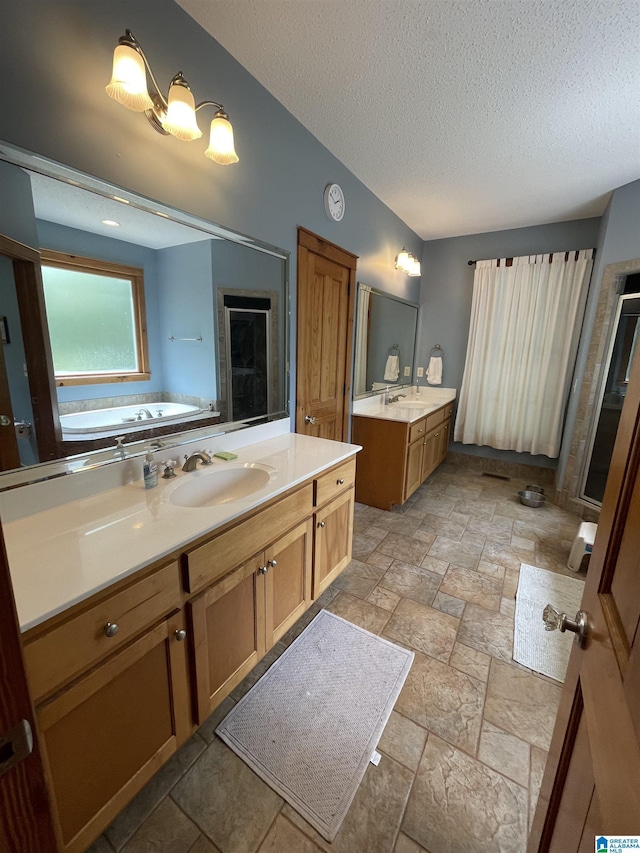720 Good Hope Delta Rd, Delta, AL 36258 - full bath with a textured ceiling, two vanities, stone tile flooring, a garden tub, and a shower