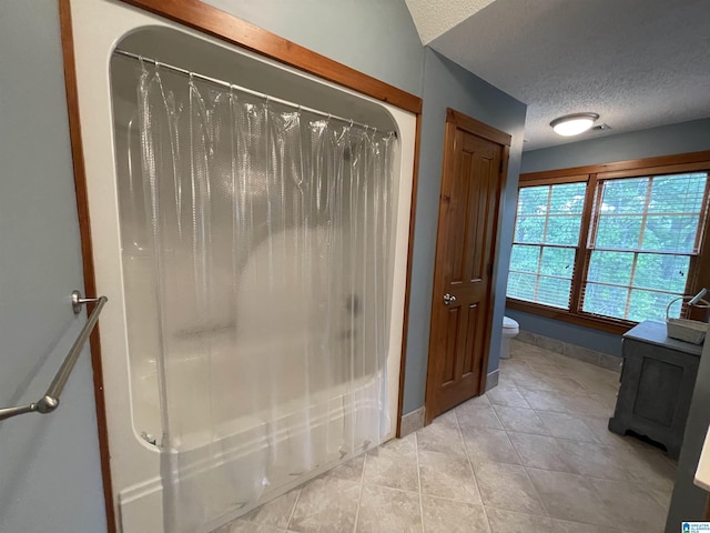 720 Good Hope Delta Rd, Delta, AL 36258 - full bathroom featuring a textured ceiling, toilet, tile patterned flooring, shower / bath combination with curtain, and baseboards