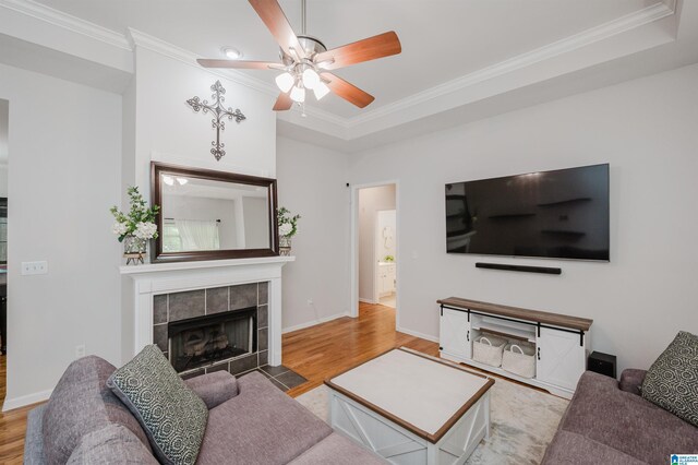 2246 Clairmont Dr, Leeds, AL 35094 - living room with wood finished floors, ceiling fan, a tiled fireplace, ornamental molding, and baseboards