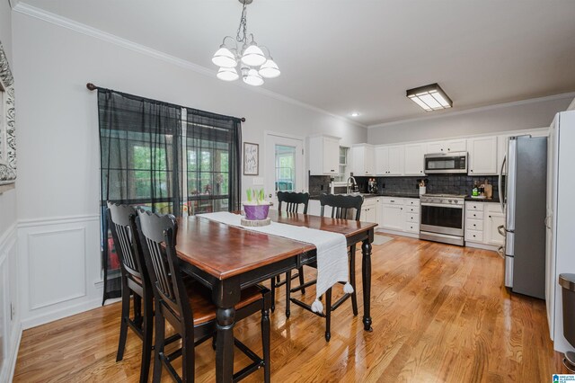 2246 Clairmont Dr, Leeds, AL 35094 - dining area with a chandelier, ornamental molding, light wood finished floors, and wainscoting