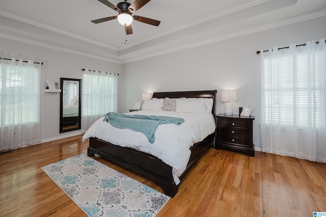 2246 Clairmont Dr, Leeds, AL 35094 - bedroom featuring light wood finished floors, a tray ceiling, crown molding, baseboards, and ceiling fan
