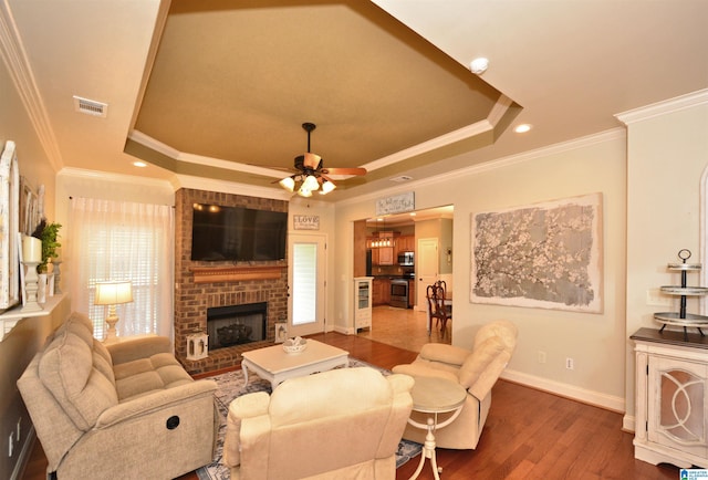 100 Weeping Cir, Wilsonville, AL 35186 - living area with a raised ceiling, a ceiling fan, dark wood-type flooring, a fireplace, and crown molding