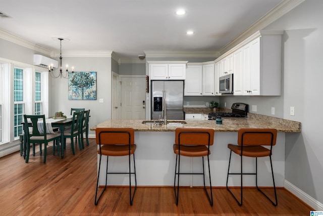 145 Lake Davidson Ln, Helena, AL 35080 - kitchen featuring stainless steel appliances, a wall mounted air conditioner, a peninsula, a chandelier, and white cabinetry