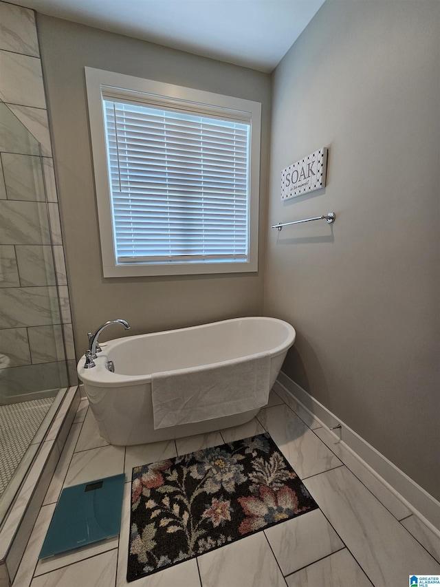 345 Easonville Park Dr, Cropwell, AL 35054 - bathroom with a freestanding bath, baseboards, marble look tile flooring, a tile shower, and plenty of natural light