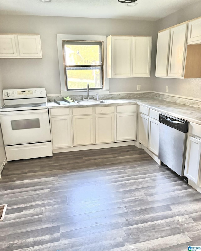 2912 Moore Ave, Anniston, AL 36201 - kitchen featuring white range with electric cooktop, stainless steel dishwasher, a sink, light countertops, and wood finished floors