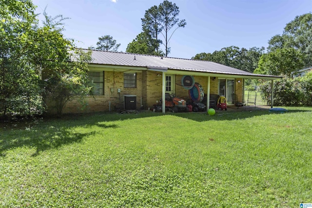 209 Meadowgreen Dr, Montevallo, AL 35115 - back of house with brick siding, a yard, central AC unit, and metal roof