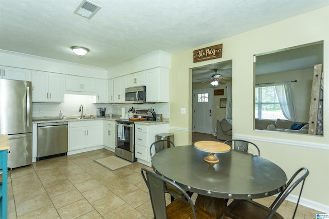 209 Meadowgreen Dr, Montevallo, AL 35115 - kitchen with appliances with stainless steel finishes, a sink, tasteful backsplash, white cabinetry, and a ceiling fan