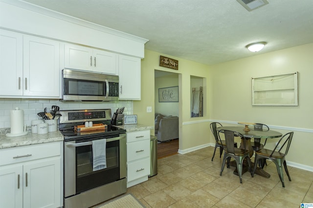 209 Meadowgreen Dr, Montevallo, AL 35115 - kitchen with appliances with stainless steel finishes, tasteful backsplash, white cabinets, baseboards, and a textured ceiling
