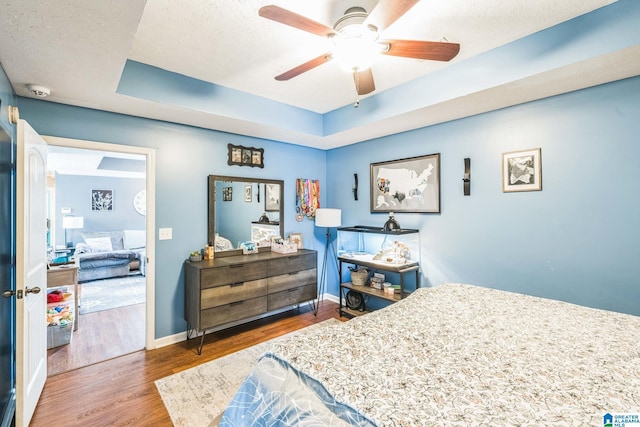 736 Buena Vista Loop, Prattville, AL 36067 - bedroom with wood finished floors, baseboards, ceiling fan, a textured ceiling, and a raised ceiling