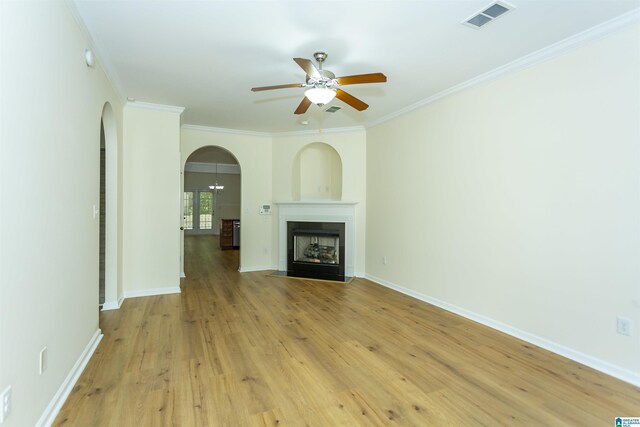 2449 Ridgemont Dr, Birmingham, AL 35244 - unfurnished living room with ceiling fan, arched walkways, light wood-style floors, ornamental molding, and a fireplace with flush hearth