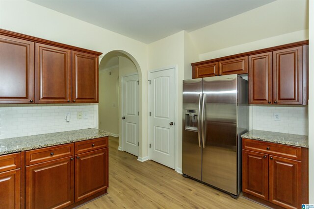 2449 Ridgemont Dr, Birmingham, AL 35244 - kitchen with stainless steel fridge with ice dispenser, light wood-style flooring, light stone counters, and backsplash