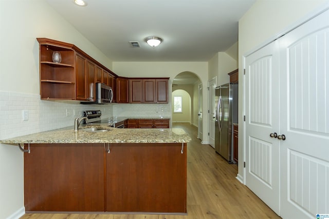2449 Ridgemont Dr, Birmingham, AL 35244 - kitchen featuring appliances with stainless steel finishes, a peninsula, arched walkways, a sink, and open shelves