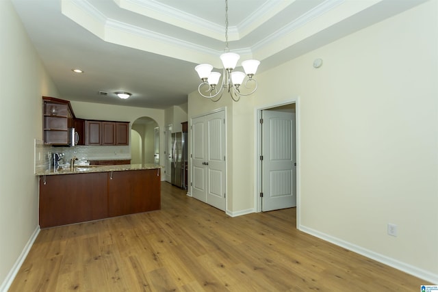2449 Ridgemont Dr, Birmingham, AL 35244 - kitchen featuring arched walkways, freestanding refrigerator, open shelves, a chandelier, and a peninsula