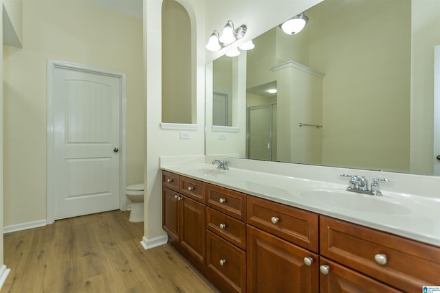 2449 Ridgemont Dr, Birmingham, AL 35244 - full bath with wood finished floors, double vanity, a shower with door, toilet, and baseboards