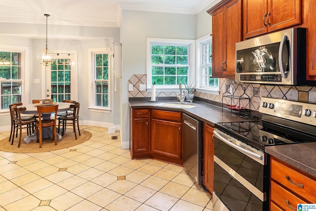7805 Rock Creek Cir, Bessemer, AL 35023 - kitchen featuring stainless steel appliances, dark countertops, tasteful backsplash, light tile patterned flooring, and crown molding