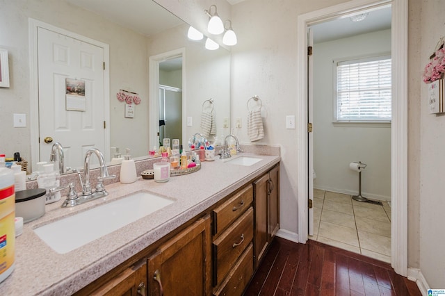 1121 Colonial Dr, Alabaster, AL 35007 - full bath with double vanity, wood-type flooring, toilet, baseboards, and a shower with shower door