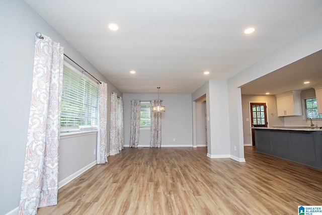 3501 Pineland Dr, Birmingham, AL 35243 - unfurnished living room with a chandelier, light wood-style floors, baseboards, recessed lighting, and a sink