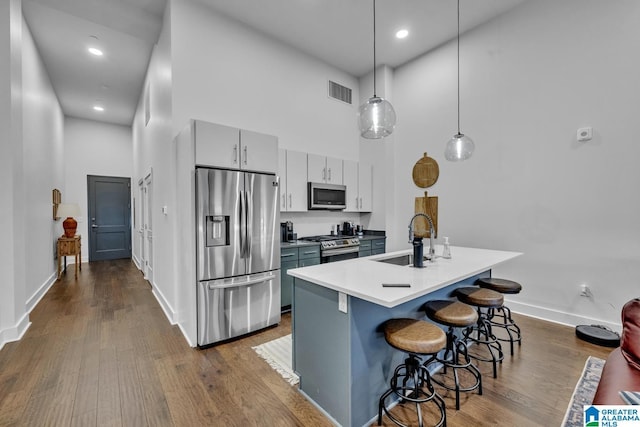 1801 2nd Ave N Unit 309, Birmingham, AL 35203 - kitchen featuring stainless steel appliances, a towering ceiling, a sink, a breakfast bar area, and baseboards