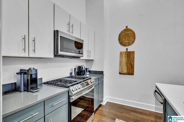 1801 2nd Ave N Unit 309, Birmingham, AL 35203 - kitchen featuring appliances with stainless steel finishes, dark wood-style flooring, baseboards, and white cabinetry