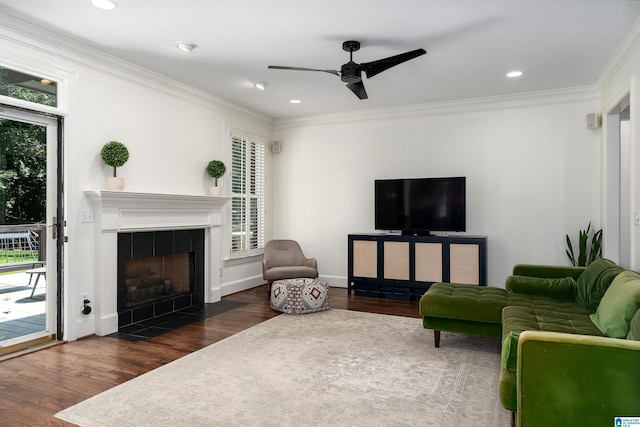 2032 Forest Meadows Cir, Birmingham, AL 35242 - living room featuring plenty of natural light, wood finished floors, ceiling fan, a tiled fireplace, and crown molding