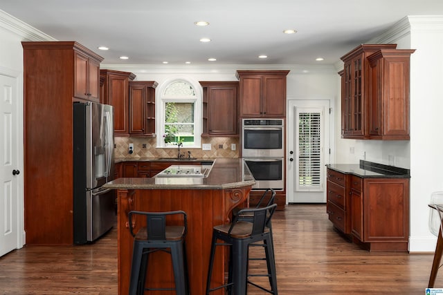 2032 Forest Meadows Cir, Birmingham, AL 35242 - kitchen featuring appliances with stainless steel finishes, dark countertops, glass insert cabinets, a breakfast bar, and crown molding