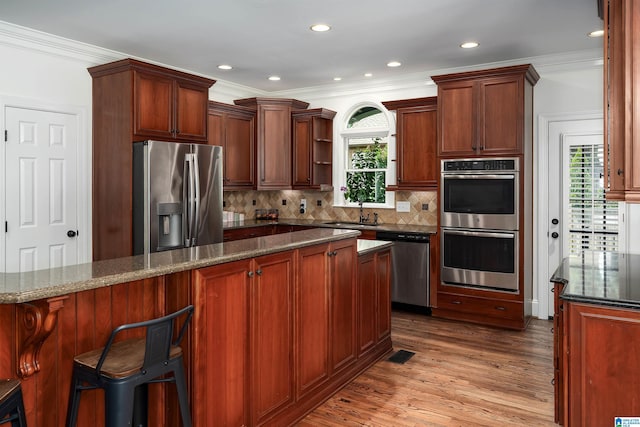 2032 Forest Meadows Cir, Birmingham, AL 35242 - kitchen featuring stainless steel appliances, crown molding, wood finished floors, plenty of natural light, and backsplash