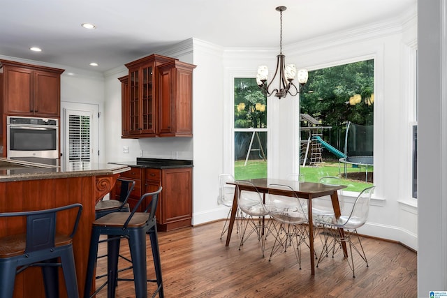 2032 Forest Meadows Cir, Birmingham, AL 35242 - kitchen with oven, dark countertops, wood finished floors, glass insert cabinets, and a chandelier