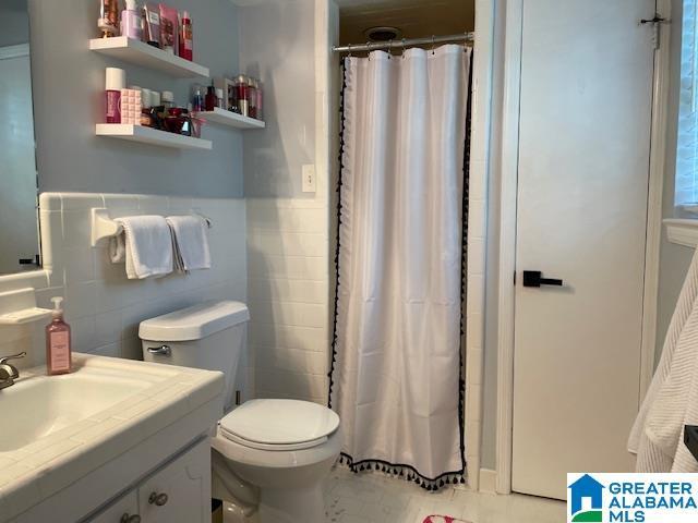 2213 Montreat Cir Unit D, Vestavia Hills, AL 35216 - bathroom with vanity, tile walls, curtained shower, and wainscoting