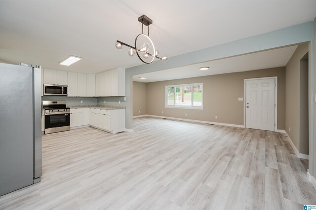 2016 NW 9th Pl, Center Point, AL 35215 - kitchen featuring stainless steel appliances, light wood-type flooring, white cabinetry, open floor plan, and a chandelier