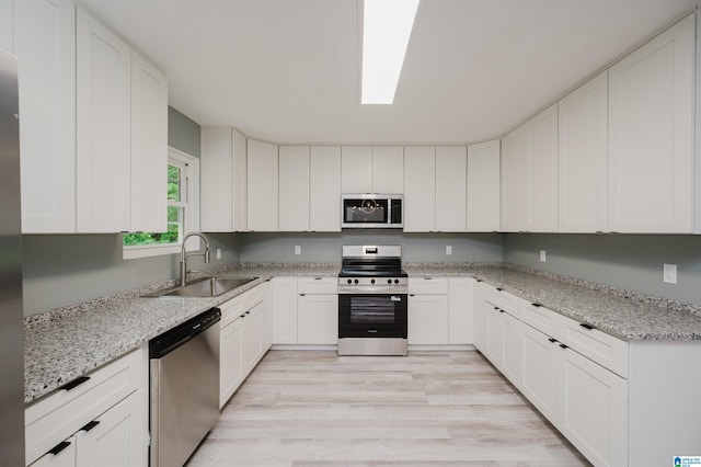 2016 NW 9th Pl, Center Point, AL 35215 - kitchen with appliances with stainless steel finishes, a sink, light wood-style floors, and white cabinets