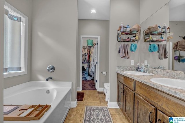 2597 Blake Way, Warrior, AL 35180 - bathroom with a bath, double vanity, tile patterned floors, toilet, and a spacious closet