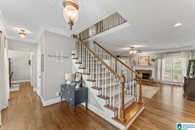 1505 Cypress Ln, Hoover, AL 35244 - stairway with crown molding, a ceiling fan, a fireplace, wood finished floors, and recessed lighting