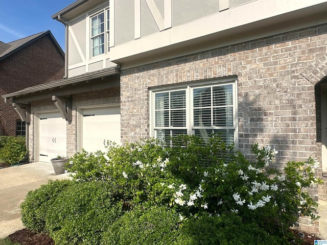 1013 Edgewater Ln, Chelsea, AL 35043 - view of side of home featuring stucco siding, concrete driveway, an attached garage, and brick siding