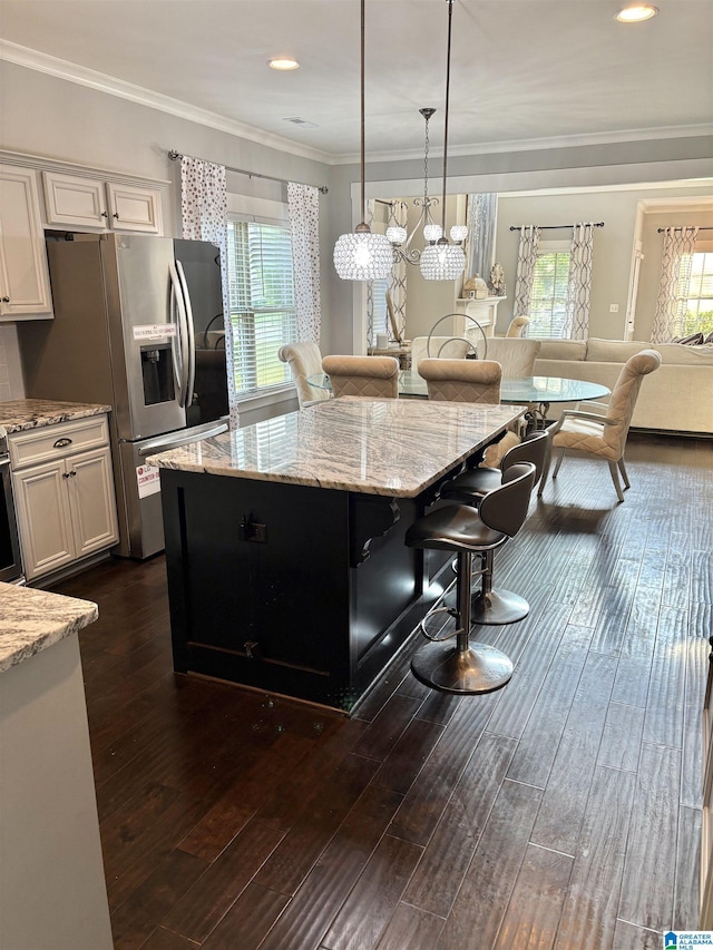 1013 Edgewater Ln, Chelsea, AL 35043 - kitchen featuring stainless steel fridge with ice dispenser, a breakfast bar area, light stone countertops, plenty of natural light, and ornamental molding