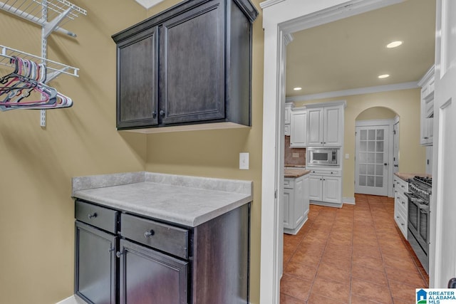 101 N Lake Dr, Hoover, AL 35242 - kitchen featuring stainless steel appliances, arched walkways, light tile patterned floors, tasteful backsplash, and recessed lighting