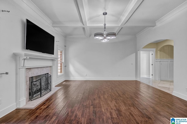 101 N Lake Dr, Hoover, AL 35242 - unfurnished living room featuring hardwood / wood-style flooring, arched walkways, a tile fireplace, a chandelier, and beamed ceiling