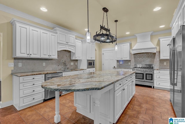 101 N Lake Dr, Hoover, AL 35242 - kitchen with appliances with stainless steel finishes, custom exhaust hood, a kitchen island, white cabinetry, and recessed lighting