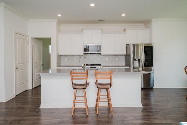 1063 Timberline Rdg, Calera, AL 35040 - kitchen featuring appliances with stainless steel finishes, an island with sink, crown molding, decorative backsplash, and white cabinetry