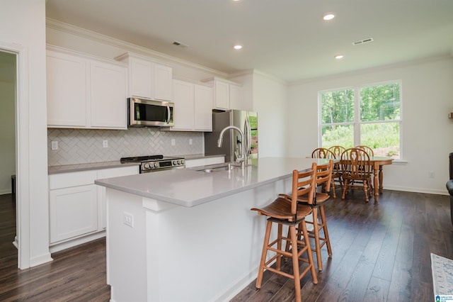 1063 Timberline Rdg, Calera, AL 35040 - kitchen featuring appliances with stainless steel finishes, a sink, an island with sink, ornamental molding, and backsplash