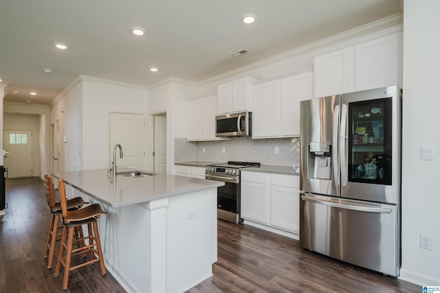 1063 Timberline Rdg, Calera, AL 35040 - kitchen featuring appliances with stainless steel finishes, a sink, an island with sink, dark wood-type flooring, and crown molding