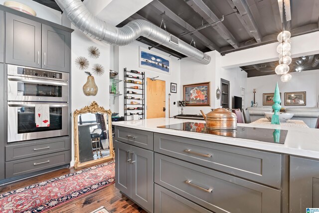 2201 1st Ave N Unit 300-C, Birmingham, AL 35203 - kitchen featuring gray cabinets, stainless steel double oven, black electric cooktop, dark wood-style flooring, and light countertops