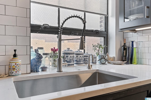 2201 1st Ave N Unit 300-C, Birmingham, AL 35203 - kitchen view of tasteful backsplash, a sink, glass insert cabinets, and light stone countertops