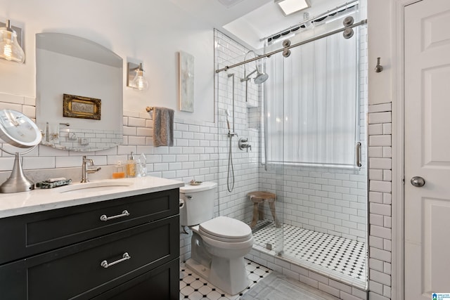 2201 1st Ave N Unit 300-C, Birmingham, AL 35203 - full bath featuring a shower stall, tile walls, vanity, toilet, and tile patterned floors