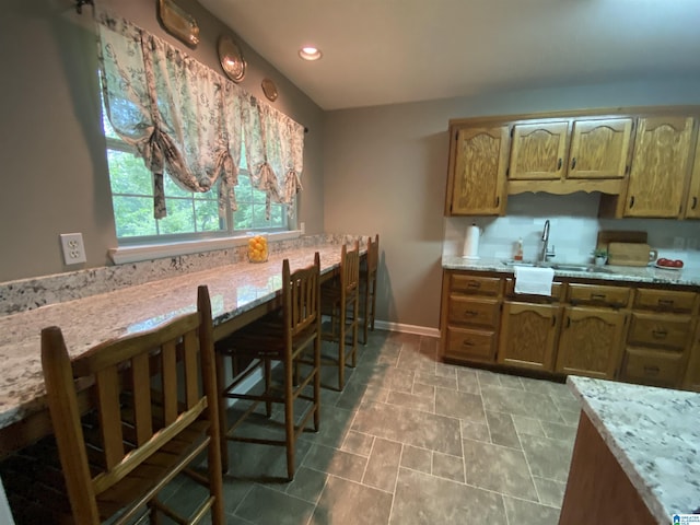 13634 Lisa Dr, Lake View, AL 35111 - kitchen featuring a sink, light countertops, baseboards, recessed lighting, and brown cabinetry