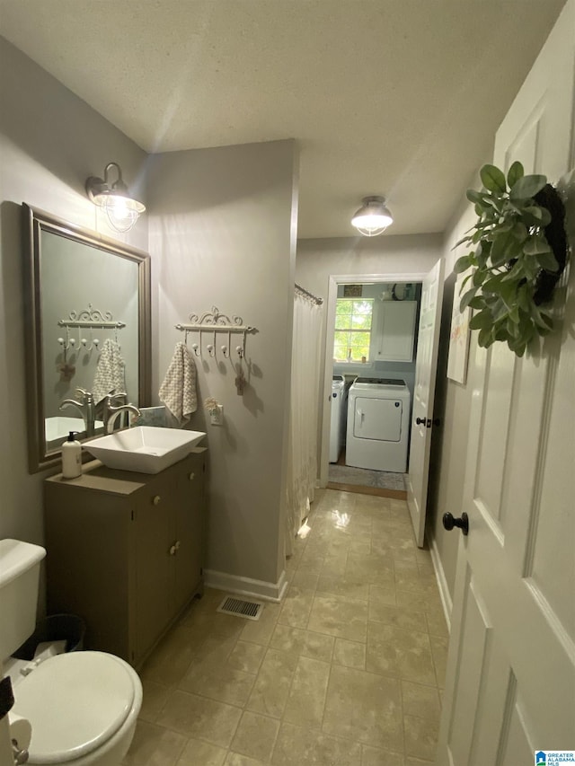 13634 Lisa Dr, Lake View, AL 35111 - bathroom with washer and dryer, toilet, vanity, a textured ceiling, and baseboards