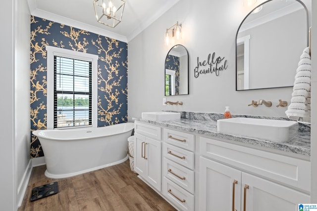 1165 Cedar Creek Dr, Sylacauga, AL 35151 - full bath featuring wood finished floors, double vanity, a freestanding tub, ornamental molding, and a chandelier