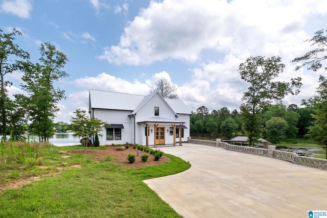 1165 Cedar Creek Dr, Sylacauga, AL 35151 - modern farmhouse featuring french doors, metal roof, concrete driveway, and a water view