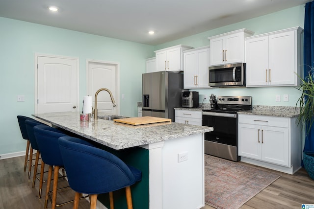 154 Halifax Ln, Chelsea, AL 35043 - kitchen with stainless steel appliances, a sink, wood finished floors, white cabinets, and recessed lighting