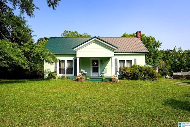 580 3rd St SW, Ashland, AL 36251 - bungalow featuring a front yard, a chimney, a porch, and metal roof