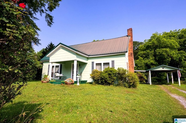 580 3rd St SW, Ashland, AL 36251 - view of front of house featuring a porch, a carport, a front yard, and a chimney